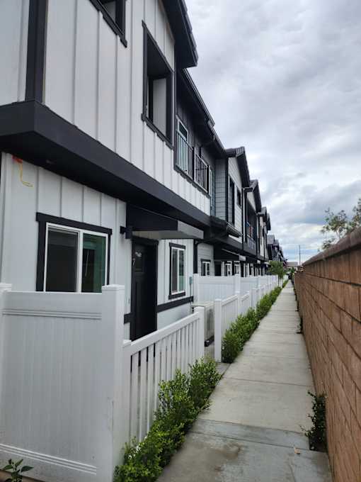 A row of white houses with black trim.