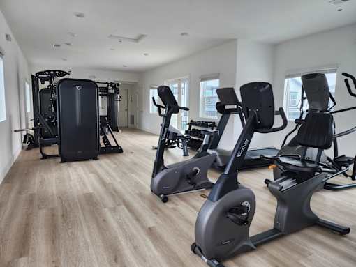 A spacious gym with a variety of cardio equipment.