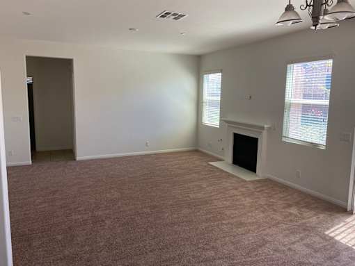 an empty living room with a fireplace and a window