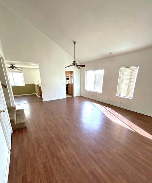 A room with wooden floors and a ceiling fan.