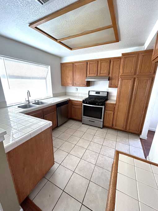 A kitchen with wooden cabinets and a white counter top.
