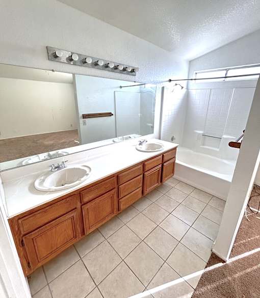A bathroom with two sinks and a large mirror.