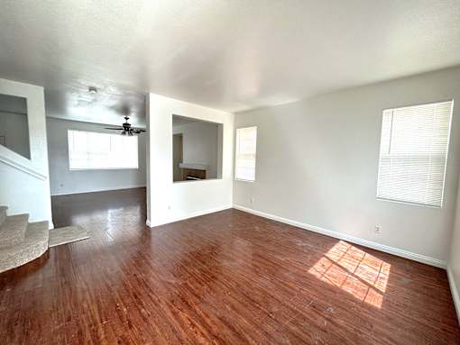 A room with wooden floors and a window letting in sunlight.