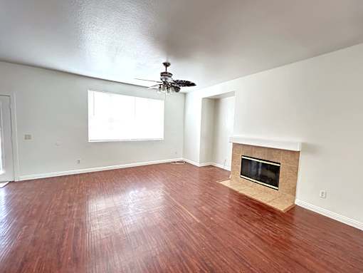 A room with a fireplace and wood flooring.