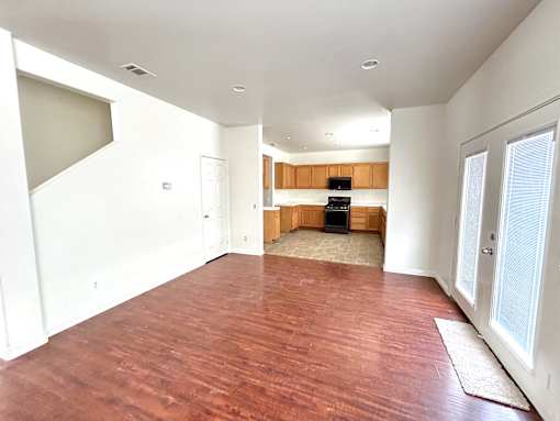 A room with wooden flooring and white walls.