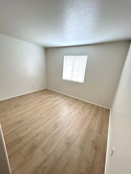 A room with a window and wooden flooring.