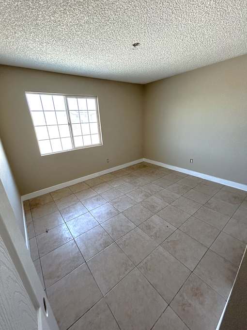 A room with a window and tile flooring.