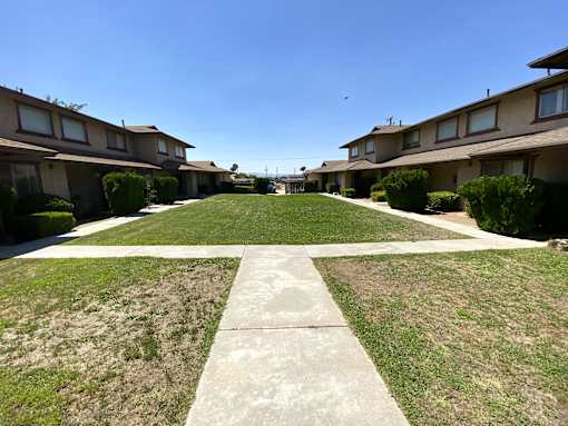A row of houses with a concrete path in the middle.
