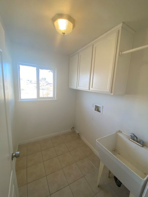A bathroom with a window and a tiled wall.