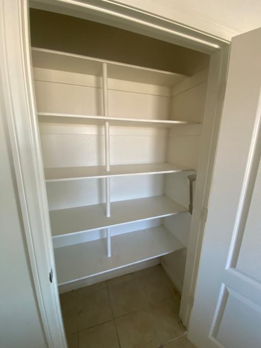 A white cabinet with shelves and drawers is open.