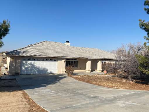 A house with a grey roof and a white garage door.