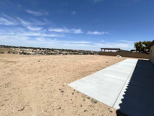 A large open area with a concrete pathway leading to a building.