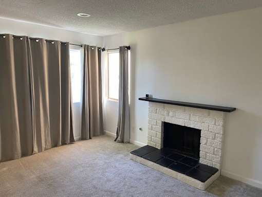 A room with a fireplace and curtains.