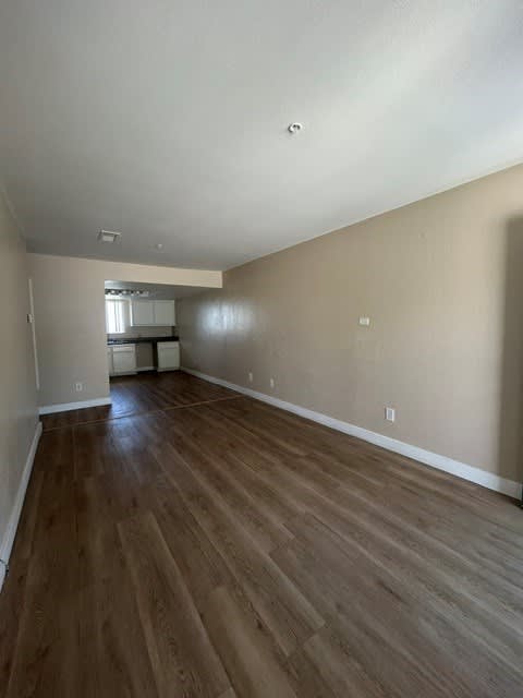 A room with wooden flooring and a window.