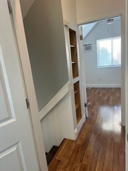 a small room with a staircase and a book shelf in it