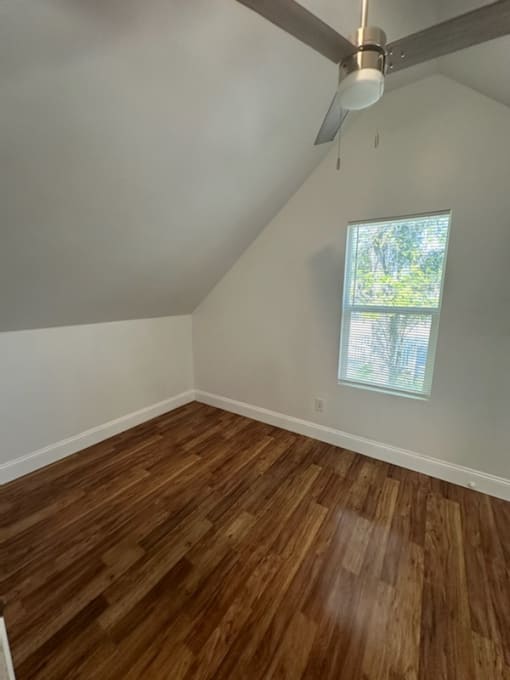 an empty room with wooden floors and a window
