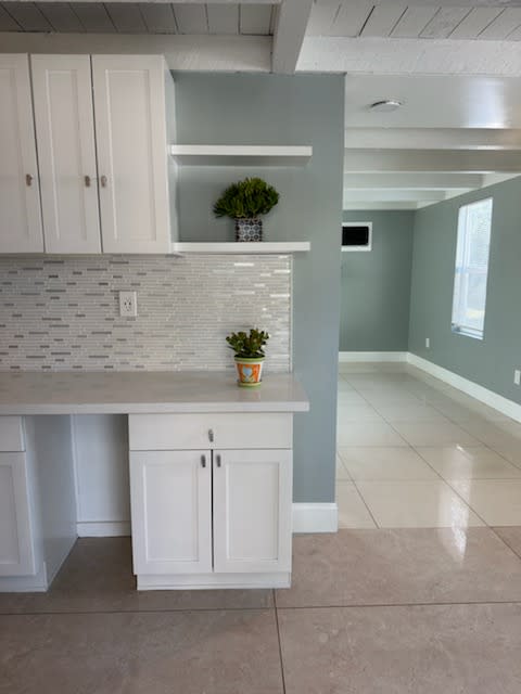 a kitchen with white cabinets and a white counter top