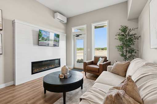 A living room with a fireplace and a flat screen TV mounted on the wall.