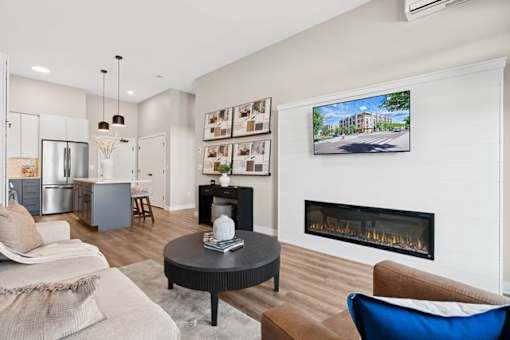 A living room with a fireplace and a television on the wall.