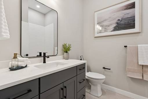 A bathroom with a white sink and a white toilet.