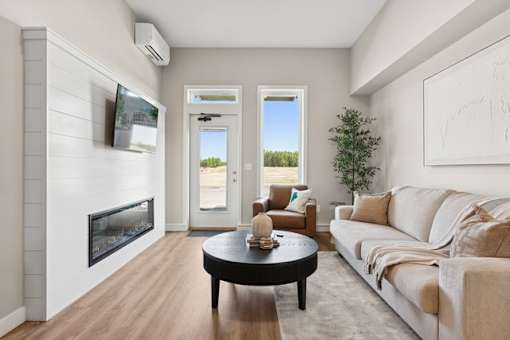 A modern living room with a fireplace and a flat screen TV mounted above it.