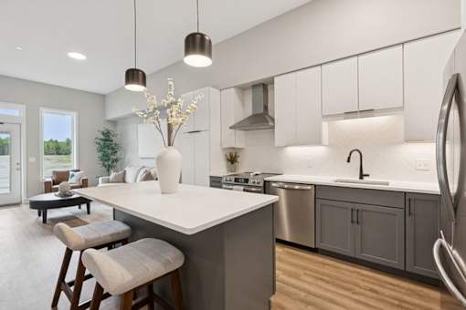 A modern kitchen with a large island and bar stools.