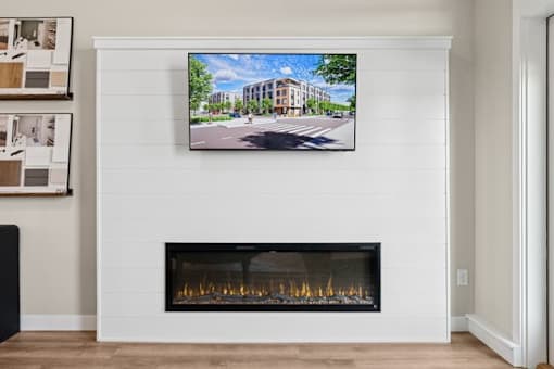A modern living room with a fireplace and a TV mounted above it.