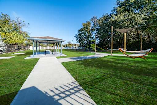 A park with a pavement leading to a pavilion. at Red Bay Apartment Complex, Jacksonville, FL, 32211