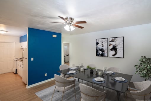 a dining room with a table and chairs and a blue accent wall