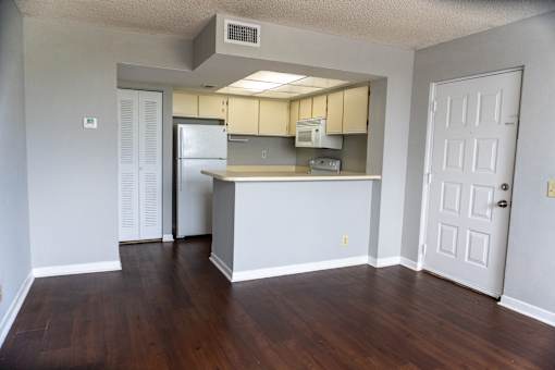 an empty living room with a kitchen with a refrigerator and  at Bella Lago Vista, West Palm Beach, FL, 33401
