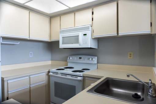 an empty kitchen with a stove microwave and sink at Bella Lago Vista, West Palm Beach, Florida