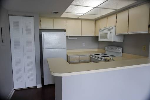 an empty kitchen with white cabinets and a refrigerator at Bella Lago Vista, West Palm Beach