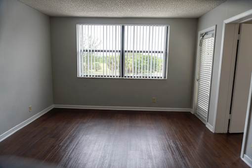 an empty living room with wood floors and a large window at Bella Lago Vista, West Palm Beach