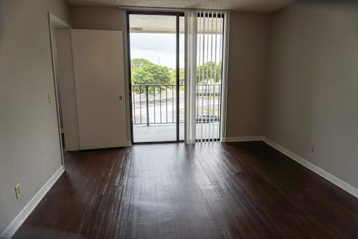 an empty living room with wood floors and a balcony  at Bella Lago Vista, West Palm Beach, 33401