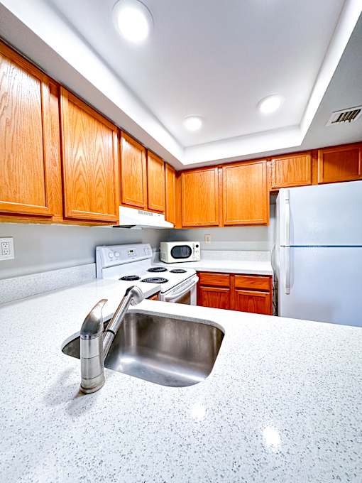 a kitchen with a sink and a refrigerator at Bella Lago Vista, West Palm Beach