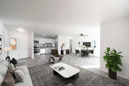 A modern living room with a grey sofa, a coffee table, and a dining area in the background. at Red Bay Apartment Complex, Jacksonville, FL, 32211