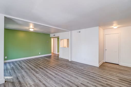 a living room with green and white walls and a wooden floor at Red Bay Apartment Complex, Jacksonville, FL, 32211