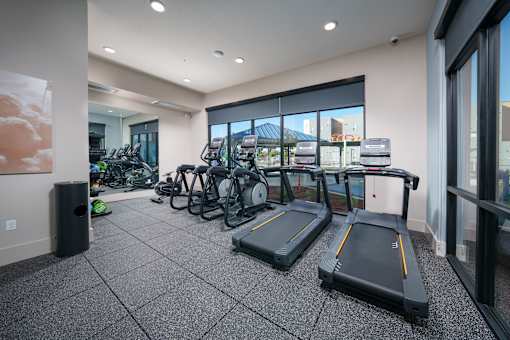 a gym with cardio machines and bikes in the lobby of a building