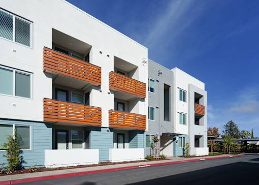 a row of apartment buildings with blue and white facade and wooden balconies