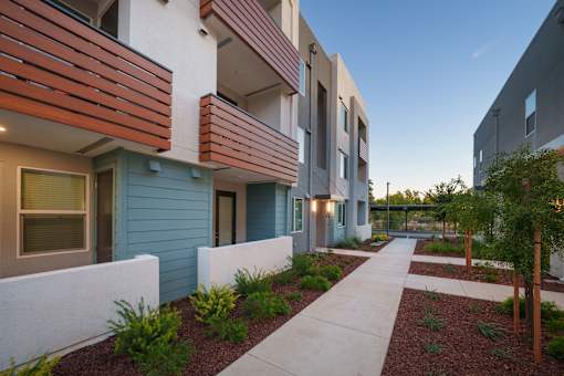 redesigned sidewalk in front of modern apartment buildings with a courtyard