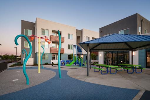 a playground and pavilion in a courtyard of an apartment building