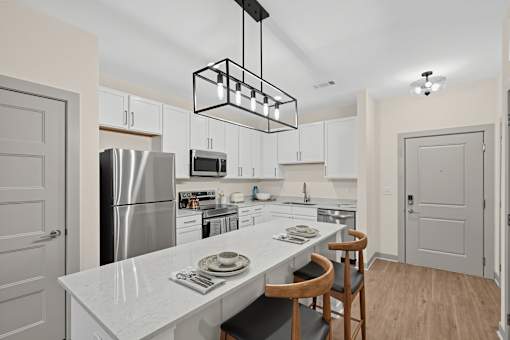A modern kitchen with a white countertop and stainless steel appliances.