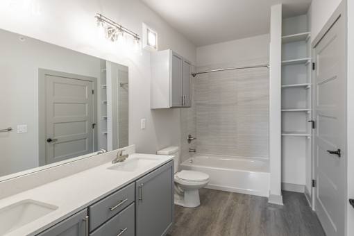 A white bathroom with a toilet, sink, and bathtub.at Allure Apartments LLC, Whiteland, 46184