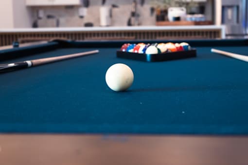 A pool table with a white ball in the middle.