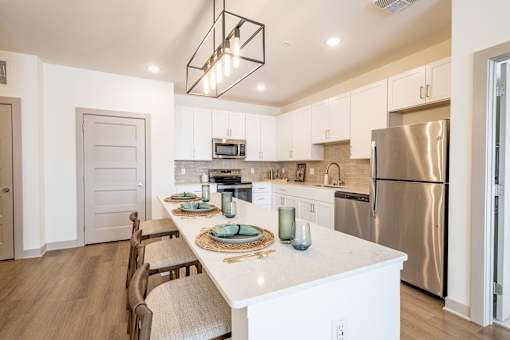 A modern kitchen with a long table and chairs.