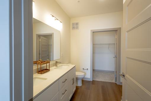 A bathroom with a toilet, sink, and mirror.