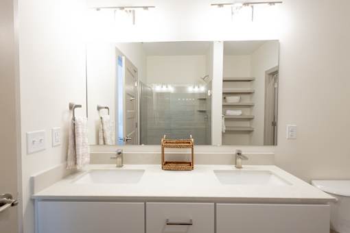 A bathroom with two sinks and a large mirror.