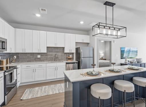 Modern kitchen with white cabinetry and island seating at Viridian Apartments, Bowling Green, KY