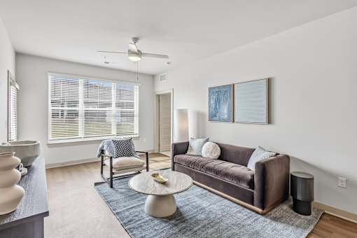 Modern living room with brown sofa and blue accents at Viridian Apartments, Bowling Green, Kentucky