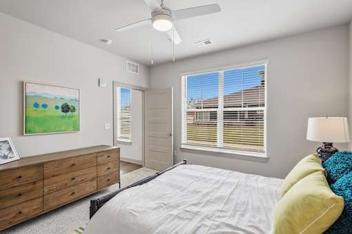 Bedroom with ceiling fan and large window at Viridian Apartments, Bowling Green